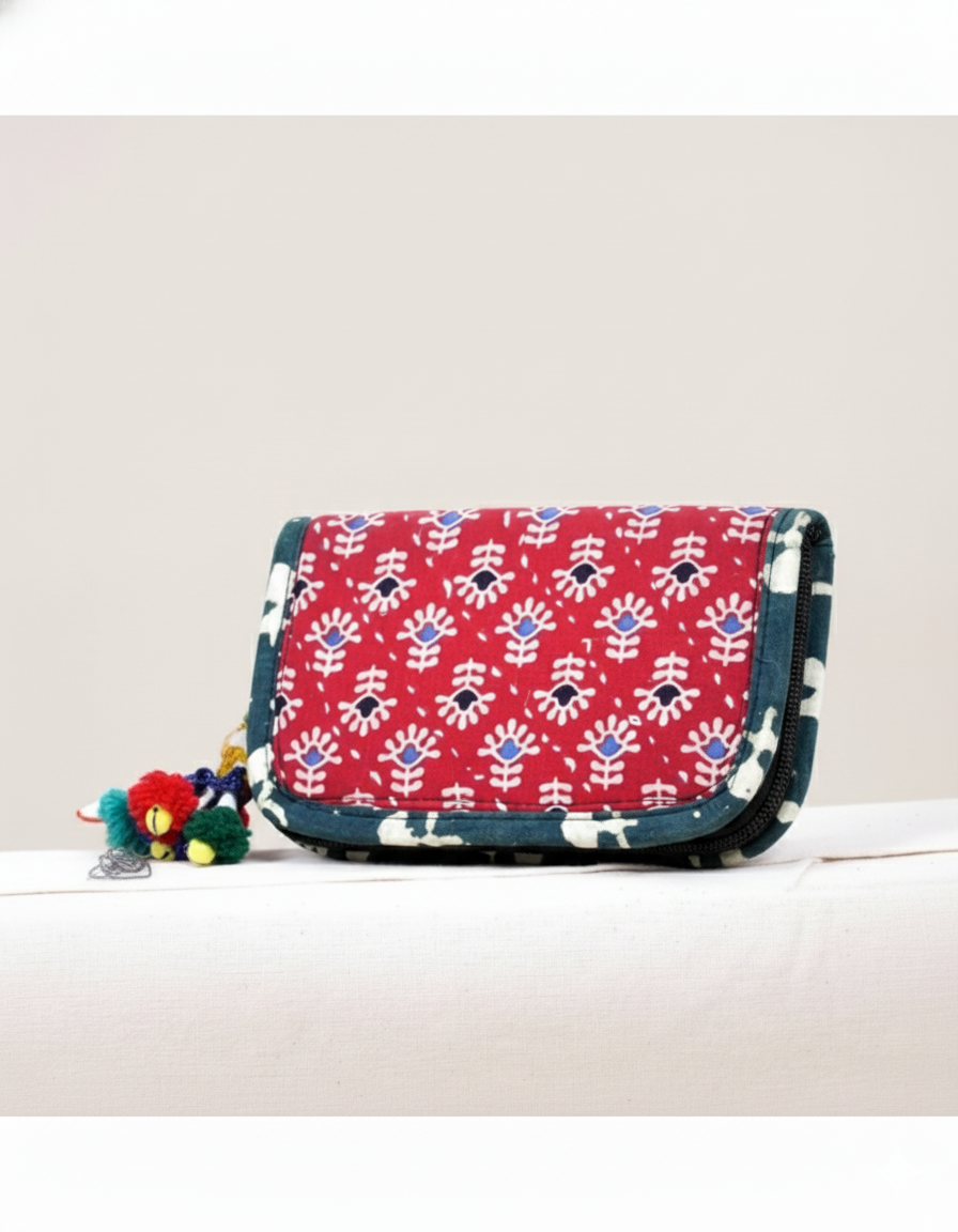 Red patterned bag with colorful tassels on a light background