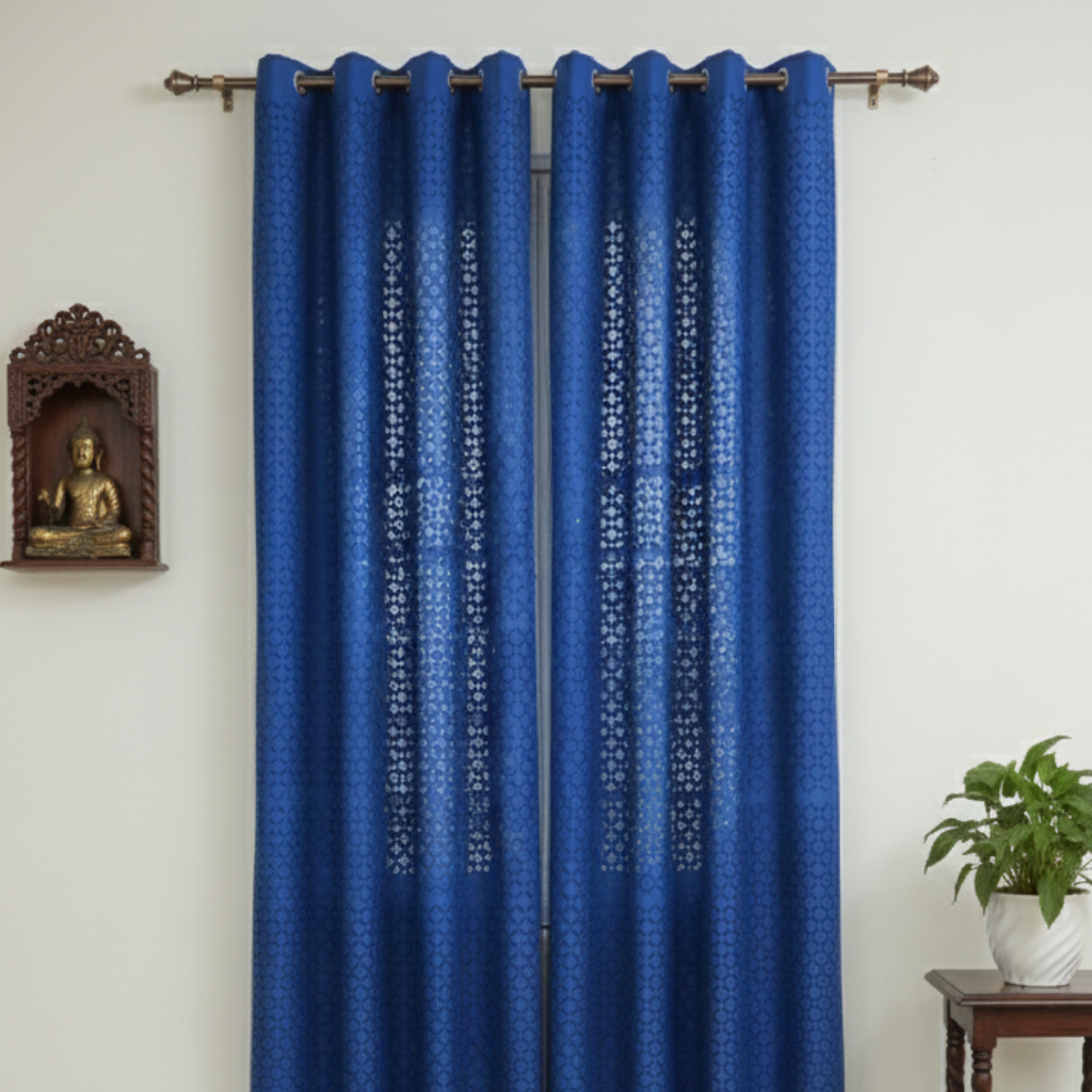 Blue patterned curtains hanging on a rod with a white wall background.