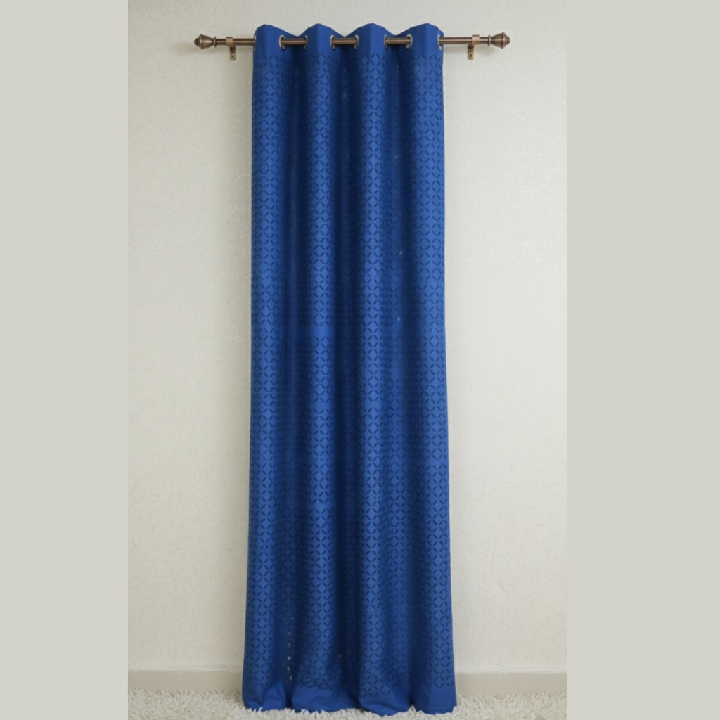 Blue curtain with a subtle pattern on a beige wall