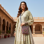 Woman in traditional outfit holding a patterned bag in an architectural setting