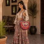 a girl in a boho skirt and top carrying a rustic red embroidered tote bag