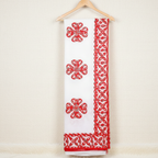 White saree with red floral patterns on a wooden hanger against a beige background