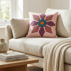 Decorative cushion cover with a colorful flower pattern on a beige sofa in a living room.