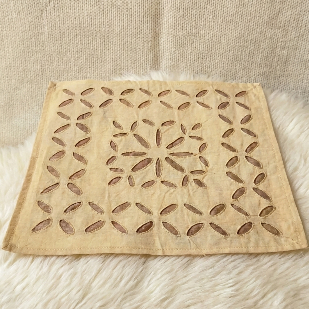 beige placemat with a starburst pattern on a textured surface