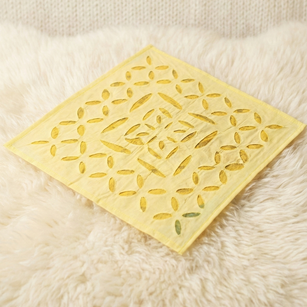 Yellow decorative mat with leaf pattern on a fluffy white surface
