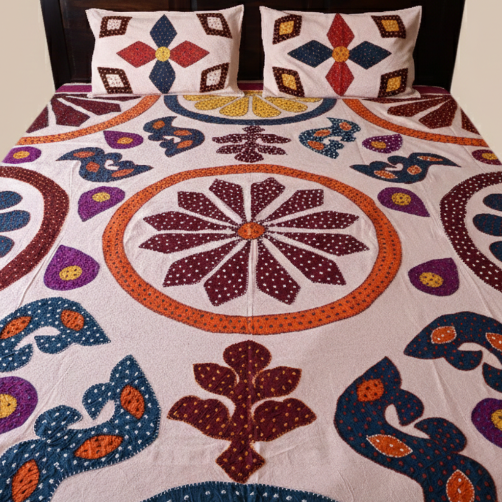 Colorful floral applique bedspread with matching pillows on a bed.