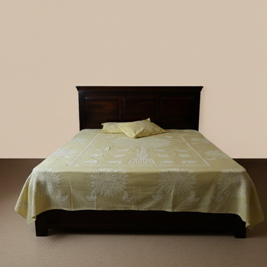 Bed with a green tree patterned bedsheet with pillows and dark wooden headboard against a beige wall.