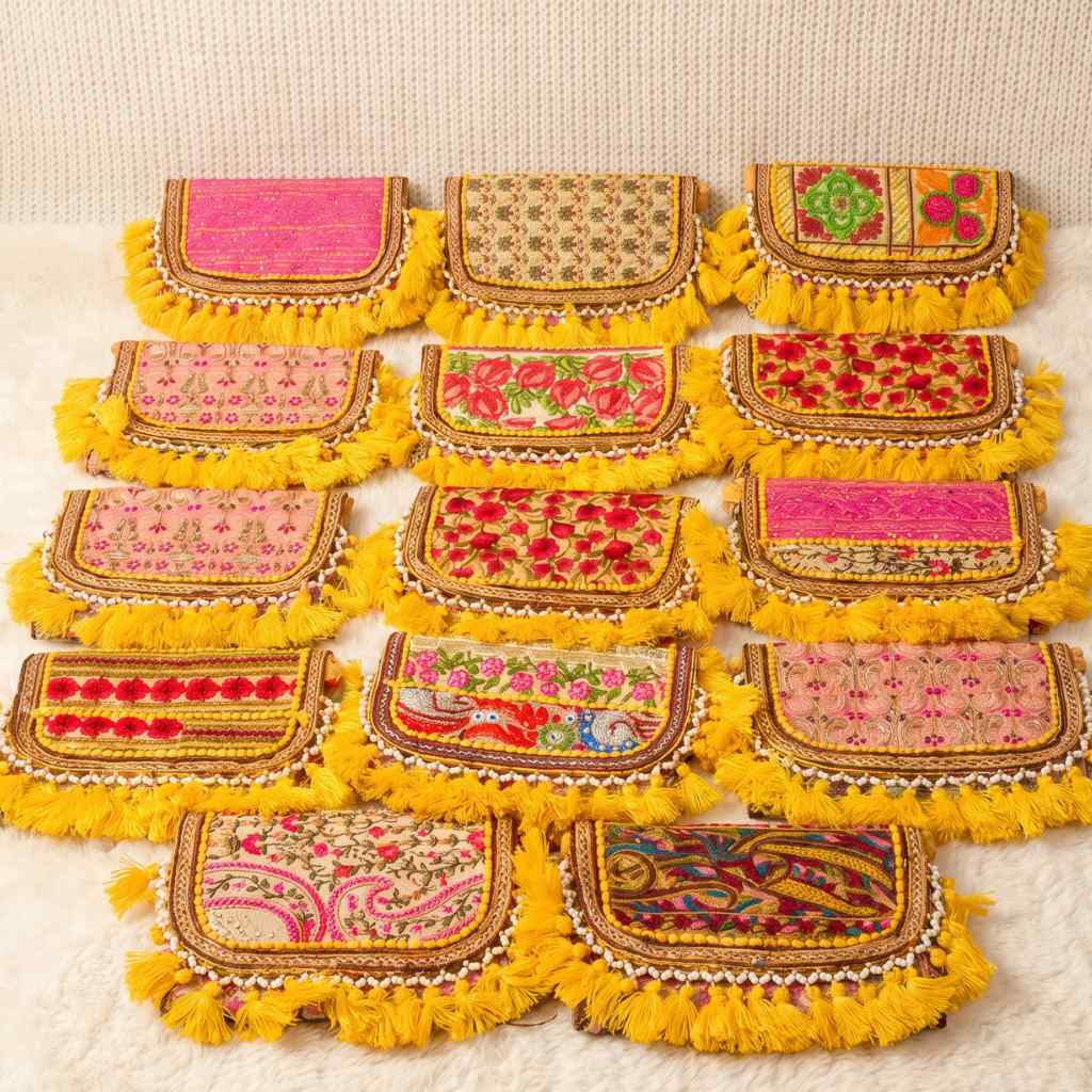 Set of colorful embroidered pouches with yellow fringes on a beige background