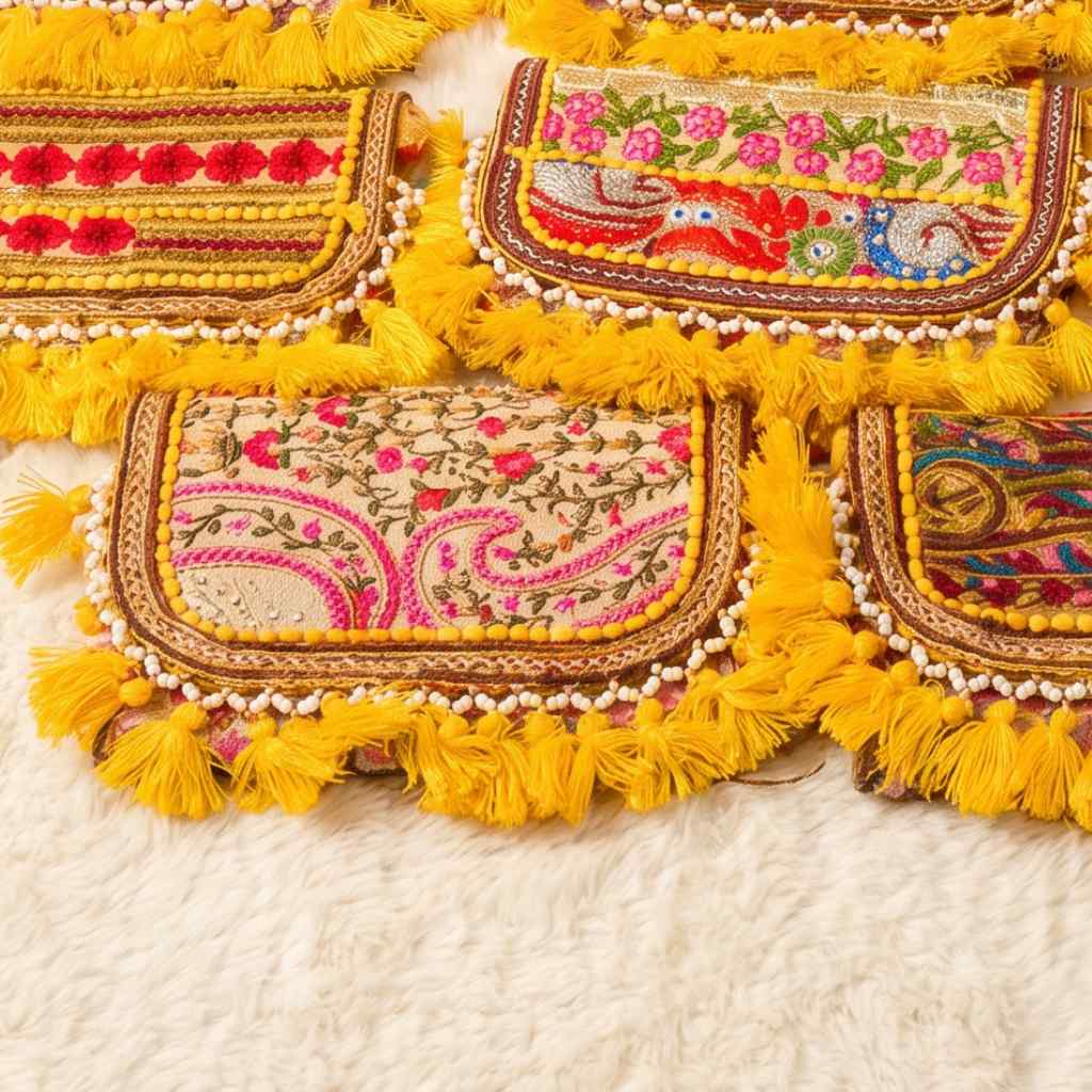 Decorative bag with colorful embroidery and yellow tassels on a white background