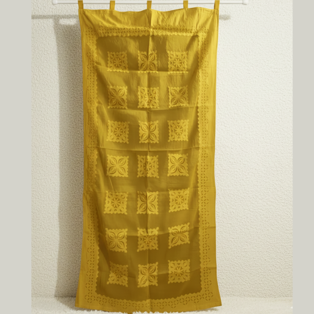 Yellow curtain with geometric pattern hanging against a white wall