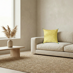Living room with a beige sofa, yellow cushion cover, and a small table with a vase.