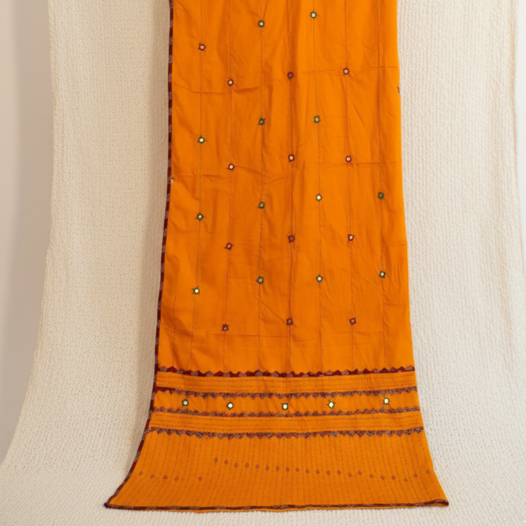 Orange applique dupatta with black patterns on a beige background