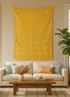 Yellow tree tapestry hanging above a beige sofa with decorative pillows in a living room.