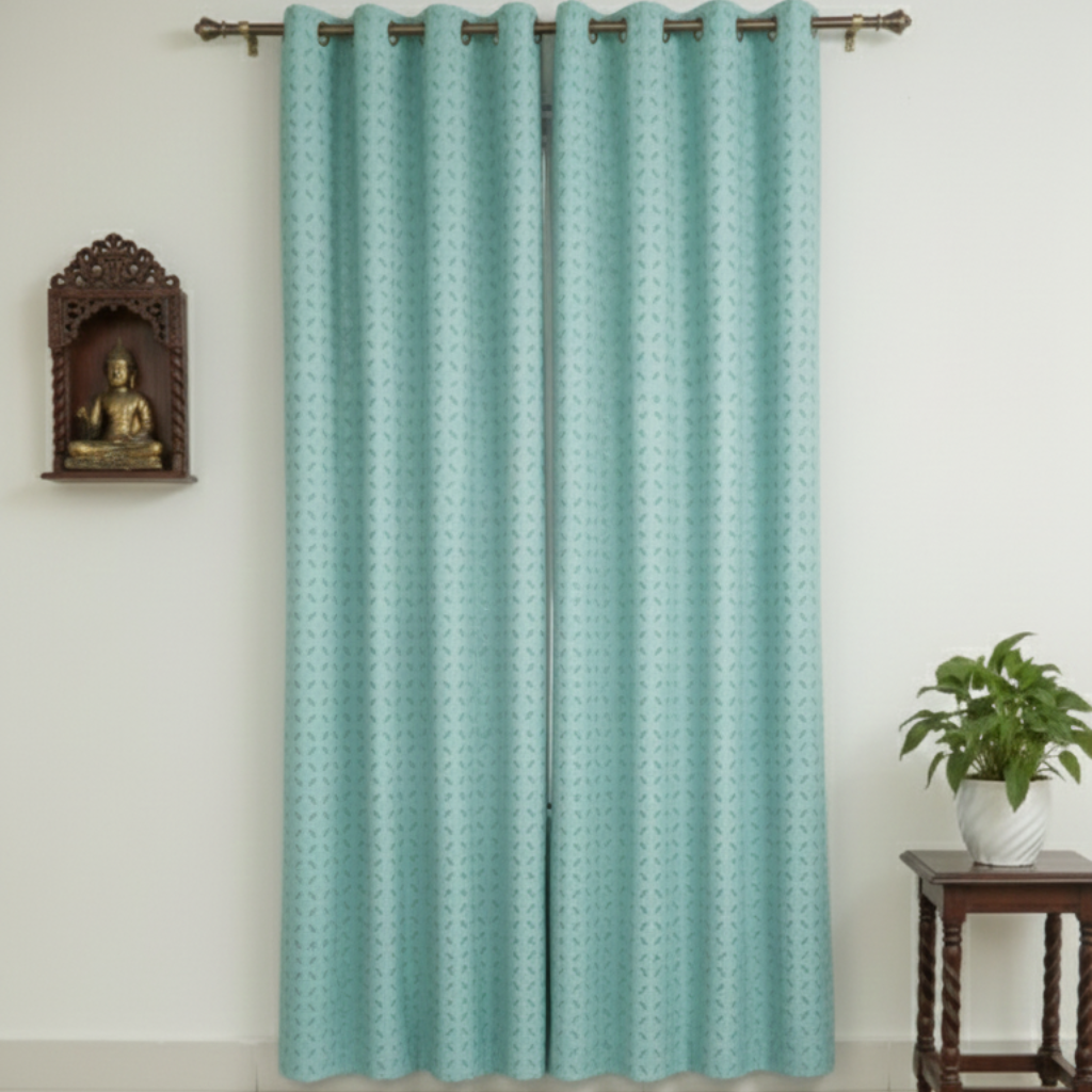 Teal curtain with a subtle pattern on a white wall with a small statue and plant.