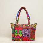 Colorful patchwork handbag with intricate patterns on a beige background