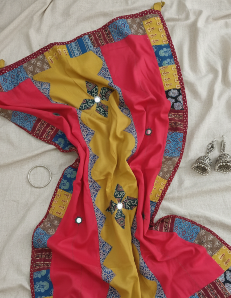 Red and yellow applique dupatta fabric with intricate patterns on a white background