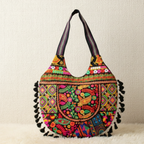 Colorful embroidered handbag with tassels on a beige background