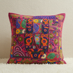 Colorful embroidered pillow on a neutral background