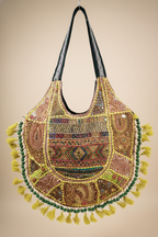 Decorative handbag with intricate patterns and tassels on a beige background
